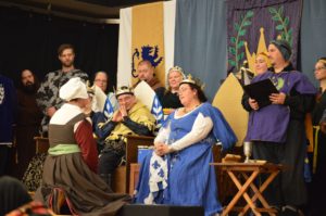 Delyth of Aberystwyth kneels before Her Majesty as she is made a companion of the Order of the Maunche